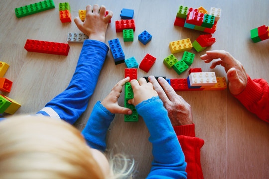 teacher and kids playing with plastic blocks