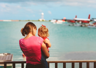 Fototapeta na wymiar mother and little daughter waiting for sea plane, travel concept