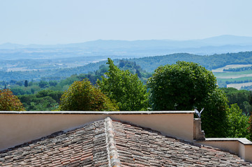 View of Tuscan hills over a tiled roof in Montepulciano, Italy