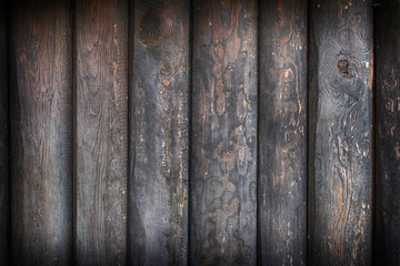 Vertical, dark old-fashioned pine planks with knots