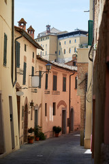 A street with colorful houses and two blank signs in Montepulciano, Tuscany, Italy