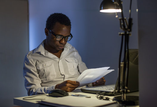 Businessman Reading Papers at Night