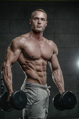 Fototapeta na wymiar Attractive model young man training in gym