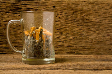 glass beer ashtray cigarette on old wood
