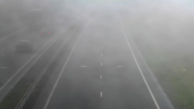 Time laspe of road traffic travelling on the A14 dual carriage in thick swirling fog. In Northamptonshire England.
