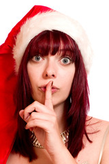 Junge Frau mit Nikolausmütze hält den Finger vor den Mund 