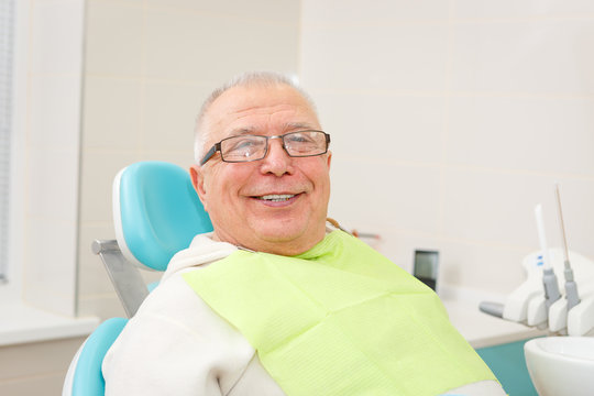 Smile Old senior man sitting in a dental chair in a dentist's office.