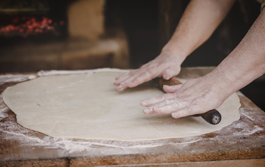Old female hands kneading dough
