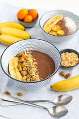 Trendy chocolate chia bowls with banana, mulberries and nuts