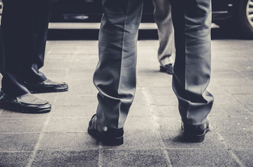 closeup of business man leg on black and gery pants with another business to business meeting talk in something to confidence