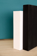 two black and white book on table with green cement wall in office