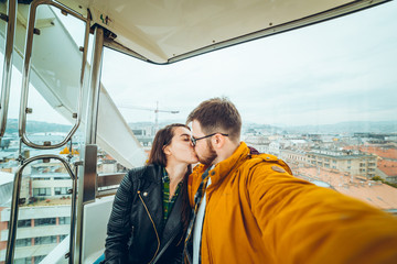 man with woman at ferris wheel taking a selfie