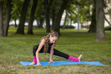 Teenage healthy lifestyle. Gymnastics exercises. Strong body for young girl, nature background. Happy sport life outdoors, fitness workout