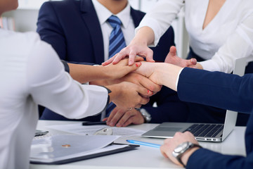 Business people group happy showing teamwork and joining hands or giving five after signing agreement or contract in office, close-up