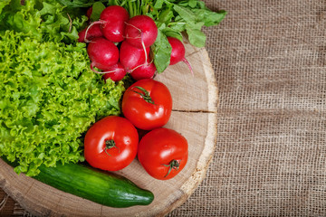 Assorted vegetables with cucumbers, tomatoes, radishes and lettuce. Top view. The concept of healthy eating and vegetarianism.