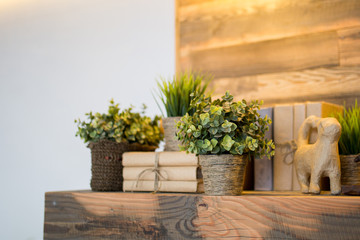 Home cozy interior. Artificial flowers and book on a wooden shelf. Eco style