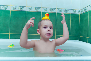 Boy in white bath tub on white background