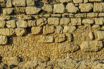 texture with ashlars of the Greek and Roman ruins of the archaeological place of Ampurias, on the brava coast in Spain.