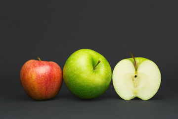 Fruit in a row, three apples on a gray background