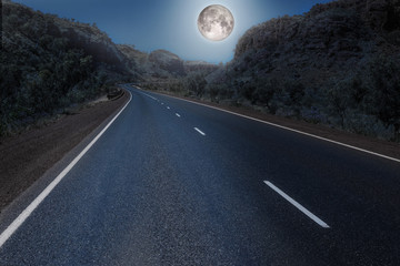 Full moon over the empty highway through the australian outback. Element of this image furnished by NASA