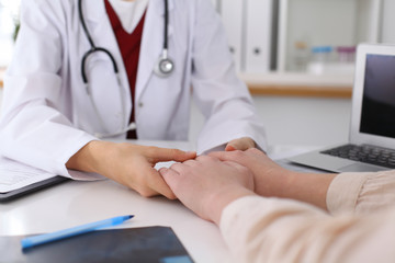 Fototapeta premium Hand of doctor reassuring her female patient