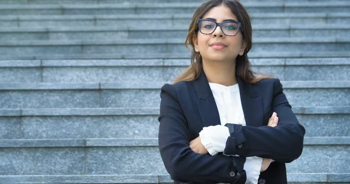 A woman in a suit, looks in camera and smiles proud and sure of himself. Concept of politics, business, finance, banking, insurance and testimonials for political campaign.	