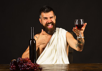 Sommelier tastes drink. Man with beard holds glass of wine