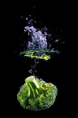 Cauliflower falling into water, isolated against black background