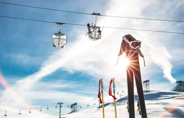 Verduisterende gordijnen Wintersport Skiing goggles and skis poles at resort glacier with chair lift on french alps - Winter vacation travel concept - High season opening on mountain slopes - Focus on sport equipment - Backlight contrast  © Mirko Vitali