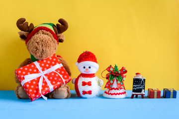 doll and gift boxes on wood desk yellow wall background