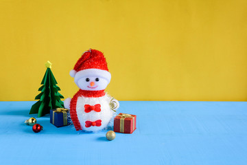 doll and gift boxes on wood desk yellow wall background