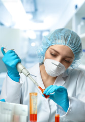 Young female tech or scientist loads liquid sample into test tube