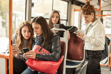 Young girl uses a mobile phone in the city bus