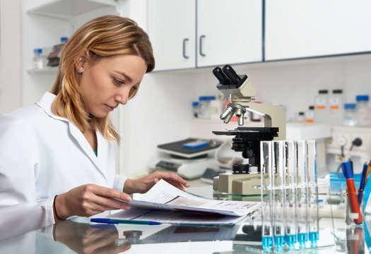 Young European female scientist checks her laboratory journal