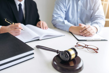 Close up of gavel, Male lawyer or judge Consult with client and working with Law books, report the...