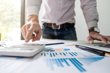Business man or accountant working Financial investment on calculator with calculate Analyze business and market growth on financial document data graph and writing ,Accounting,Economic,commercial