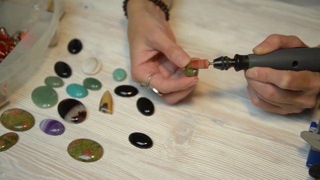Woman Jeweler working with gemstone pendants