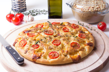 Fresh bread focaccio with tomatoes, cheese brynza, garlic and thyme. Traditional Italian bread. Selective focus, close-up.