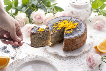 chocolate cake with orange and poppy seeds on a white background with roses