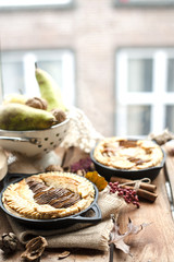 pie with pear and nuts in a frying pan. on a windowsill overlooking the city