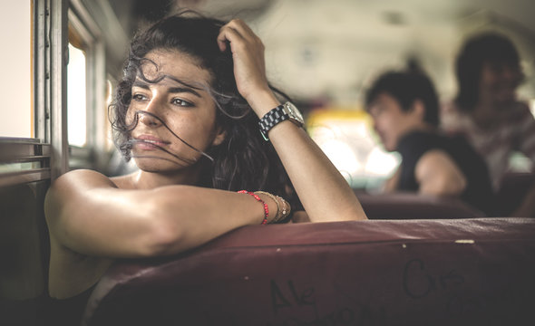 Young woman sitting on school bus looking out of window