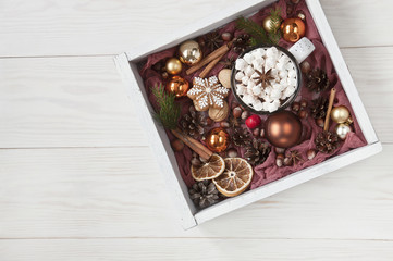 Hot winter drink with marshmallow, gingerbread and nuts. Christmas composition, on a white wooden background, top view