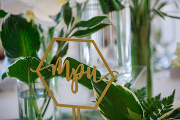 Geometrical figure with table number stands before greenery