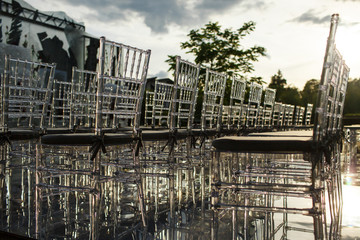 Sun shines over transparent plastic chairs on tha backyard