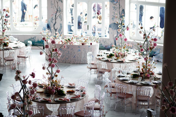 Centerpiece made of pink flowers stands in the middle of pink dinner table
