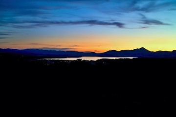 Obraz premium City lights with a background of the magic color sky above the Liptovsk Mara dam at sunset.