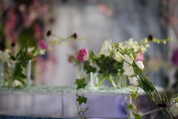 Glass box with long bouquet of pink, white and violet peonies, hydrangeas and roses