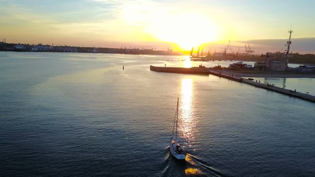 Yacht sailing in sea during sunset or sunrise. Sailing boat from drone