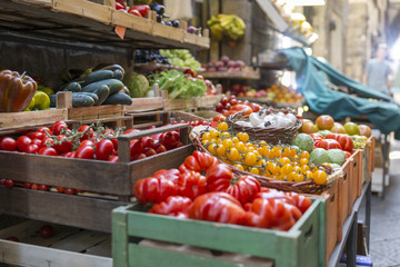 Fresh and healthy vegetables and colorful fruit in front of a shop in a picturesque street in Italy