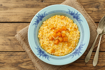 risotto italiano con zucca gialla  su sfondo rustico